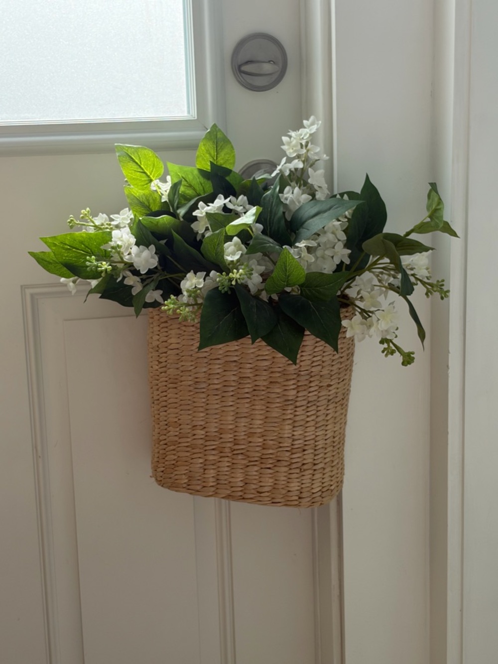 Woven Hanging Basket with White Blossoms and Green Foliage